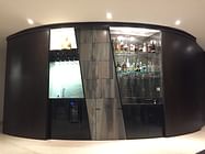 Space saving home bar with curved sliding doors and a retractable table and stool set. 