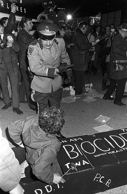 A policeman telling Earth Day protesters to leave the premises at Logan Airport. In protest against the airport’s air pollution, its expansion, and the arrival of supersonic jets, demonstrators staged a mock funeral in the lobby, with coffins. Project: Earth Day; Boston, MA, USA, 22 April 1970. Photo: Spencer Grant