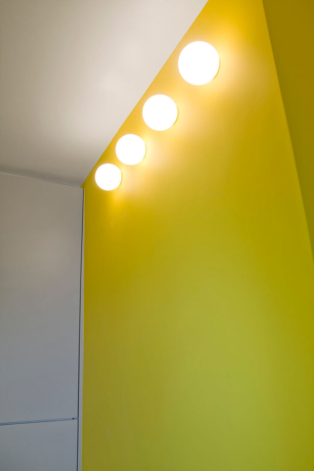 Yellow wall and globe lighting in kitchen