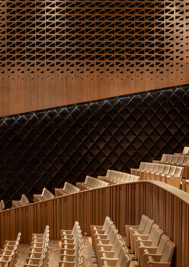 The seats in the Recital Hall have the same golden fabric as the Concert Hall and oak lines the walls. The upper part of this hall is enclosed by a circle of sound absorbing curtains, allowing for the reverberation time within the space to be tuned to specific types of performance. Image by Ethan Lee.
