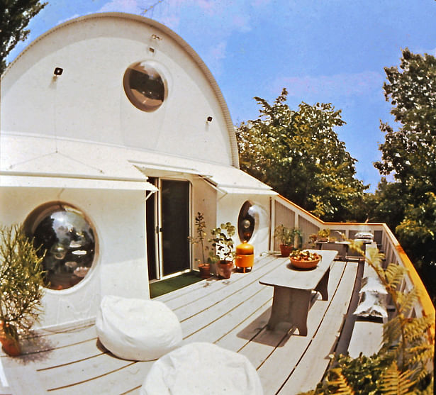 The south side of the house with a large deck and insulated panels in the lowered position