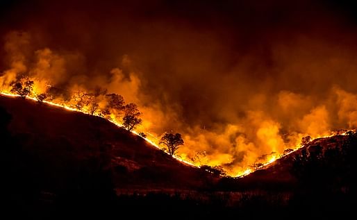 Tree ridge in flames during the 2018 Woolsey Fire in California. Photo courtesy of Peter Buschmann/Wikimedia Commons.
