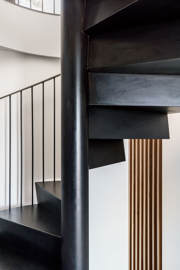 Folded steel plate treads and risers gives the stair a sculptural feel. Oak screen provides natural light to the exercise nook beyond.