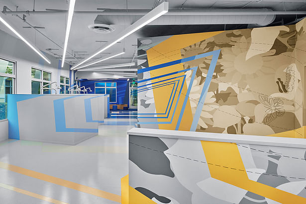 Reception Wing Check In | The journey at the children's dental clinic begins at the check-in desk, featuring a detailed feature wall as a backdrop that ties into the overall supergraphic to greet the new young patients to the practice