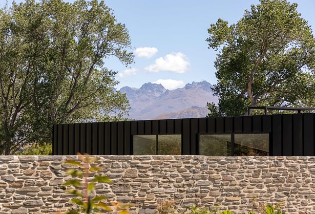 Lake Hayes Home, Queenstown, by Ben Hudson Architects - clerestory windows peek above stone wall