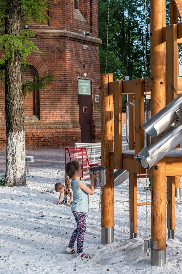 The playground is equipped with wooden objects for playing with white marble sand.