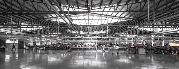 Interior view of the built facility showing the rhombus- shaped skylights, and the working conditions within.