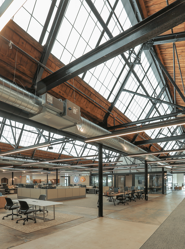 The new office space maintains the openness of a factory floor, with the heart of the space being a workstation bullpen.