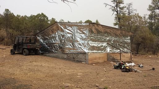 Lolo Engine 416 firemen wrap a cabin in Aluminized Structure Wrap (cabin wrap) to protect the building from radiant heat and burning embers from the Silver Fire. Photo courtesy of the U.S. Department of Agriculture