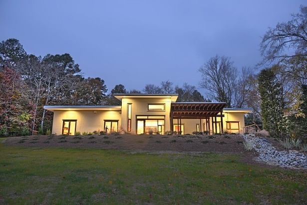 View of the southern (rear) elevation from the meadow at dusk.