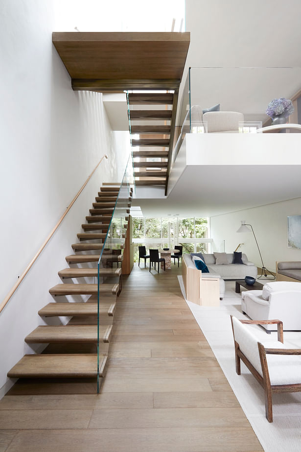 The floating treads and glass balustrade of the main staircase help to maximize the natural light flowing down through the house.