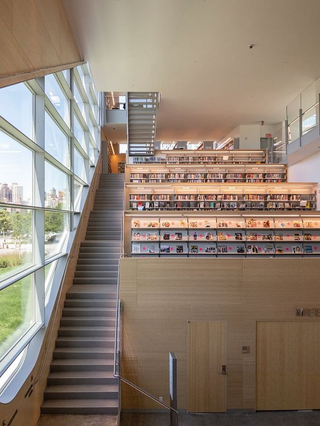The library's fiction collections are organized along a set of tiered levels that can only be accessed via staircase. Photo © Steven Holl Architects