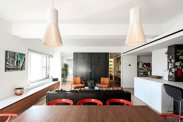 Open Living, Dining, and Kitchen with Black Steel Accent Wall and Eclectic Furnishings