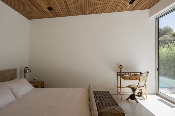 'The master bedroom occupies an opposite wing of the house, with sliding glass doors providing access to the patio. Applebaum designed the bed and bedside table while the desk is by Jacques Adnet, the amp from Marcel Breuer, and chair by Carlo Bugatti from Blackman Cruz.'