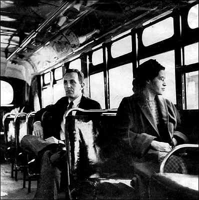Rosa Parks riding a Montgomery bus immediately following the decision to desegregate buses. Sitting behind Parks is United Press International Reporter Nicholas C. Chriss. Photo via Wikipedia.