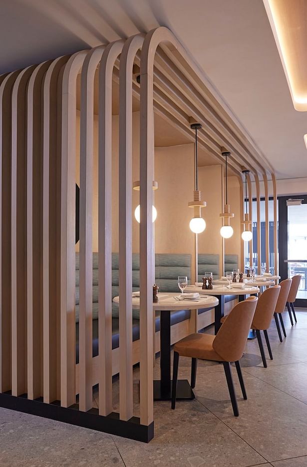 A banquette in the restaurant serves as a playful diversion with structural relevance, as walls were opened up in reconfiguring the F&B for connectivity with the outdoors (credit: Noah Webb)