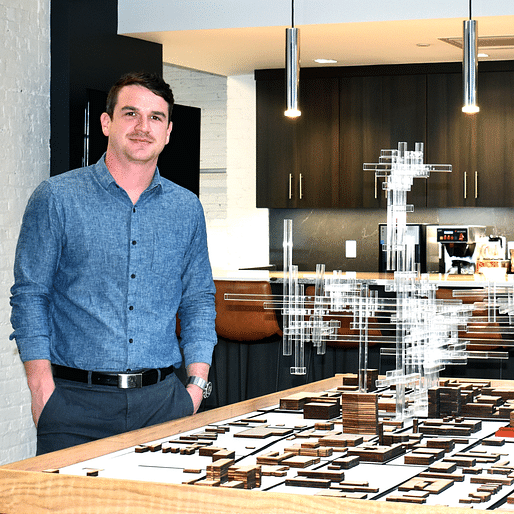 Newly licensed architect Mark Thomas with a speculative model he helped design for an event at the Speed Art Museum. 