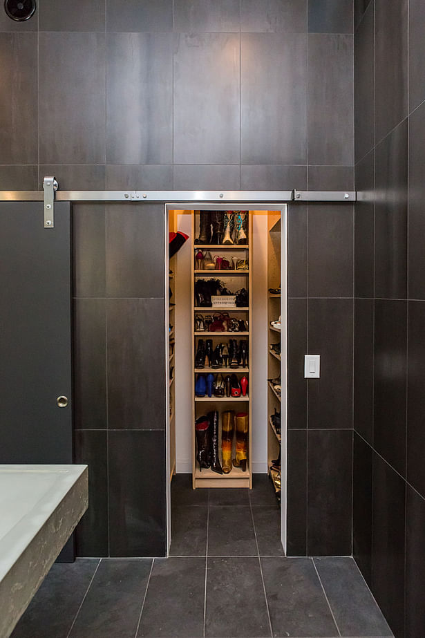 Another barn door slides open to reveal the display closet the architect designed for the owner's collection of designer shoes.