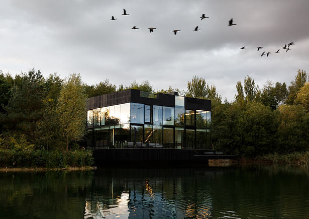 The exterior of the house is designed to disappear/minimally interfere into/with the landscape with the trees, lake and sky reflecting on the glass facades. Image by mariashot.photo 