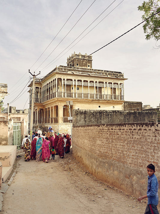 A wedding party brightens up the streets of Mahansar. The Tolaram Haveli — the inside of which is dazzlingly painted — is in the background. Credit Nick Ballon