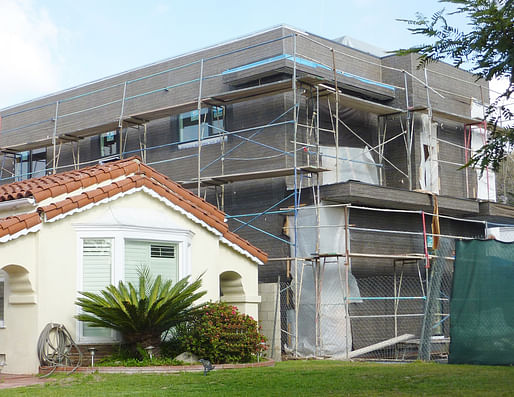 A hatching McMansion looms over its grumbling neighbor. (Image via nomoremcmansionsinlosangeles.org)