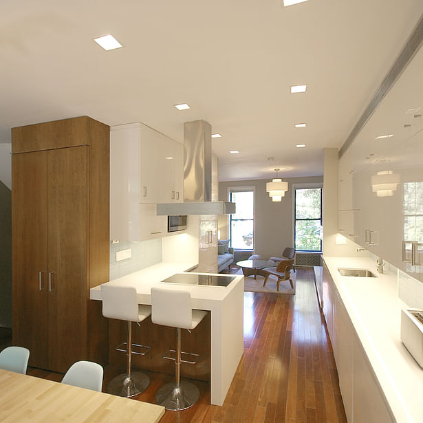 Crisp, white kitchen with walnut accents at the center of the newly open floor plan