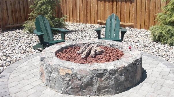 Natural gas fire pit built with chisled granite. This was surrounded by Cedar trees to create a very private feel sectioned off from the house and rest of the backyard