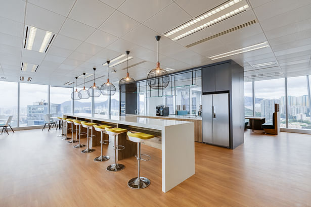 Bar stools line the sides of the pantry, offering a casual setup for informal conversations - City Facilities Management in Hong Kong by Space Matrix