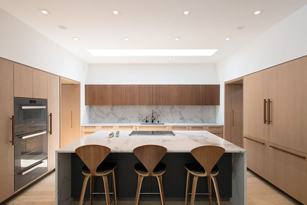 The new kitchen includes new custom white oak built-ins, faux marble countertops, and a new skylight - speaking to the existing throughout the home.