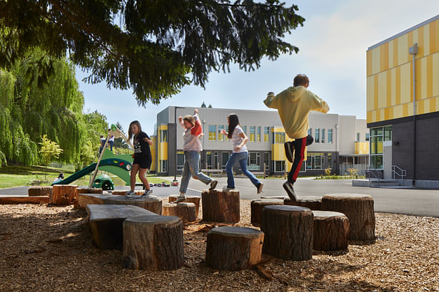 Outdoor areas beneath a grove of mature evergreens provide choices for individual, small group, or large group play. © Benjamin Benschneider
