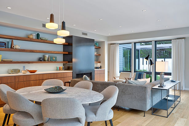 The dining and living space is anchored with a wall of walnut cabinetry and floating shelves to the north. Credit: Brian Bailey