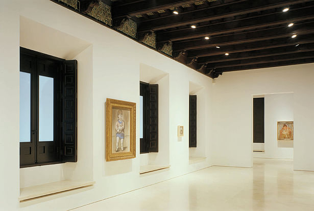 Permanent collection gallery with restored wood windows and new lighting and mechanical discretely inserted into decorative wood ceiling.