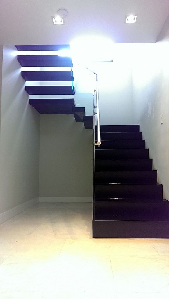 Floating stair treads transition from closed risers to open risers as you ascend upstairs.