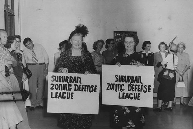 Two women hold signs which read, 'Suburban zoning defense league.' February 16, 1957. Photo courtesy of The Los Angeles Public Library.