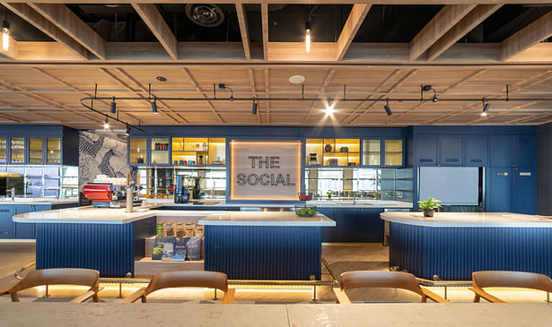 In order to attract attention as a gathering place for guests and employees, “The Social” communicates a strong design personality, with its use of diffused lighting, striking and unusual deep blue counters and cabinetry that dynamically contrast against light wood.