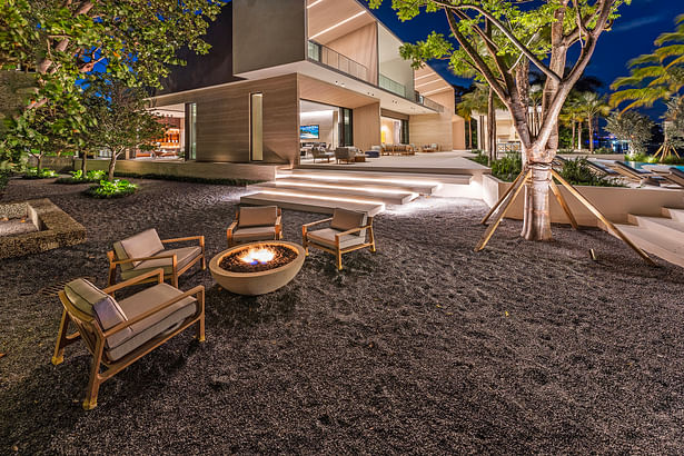 Intimate outdoor lounge area with a stone fire pit. 