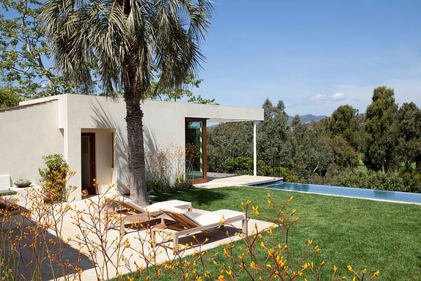 Mahogany detailing, a flat roof and a cantilevered overhang in stucco and slats gives the guest house a more modern feel.