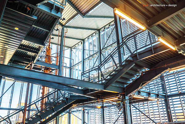 Inside the Manufacturing Atrium. The 48-foot-tall copper still is visible (left) as it rises through the space,