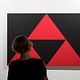 Woman in front of Carmen Herrera's '3 Red Triangles' (2016). Courtesy of Fondation Cartier. 