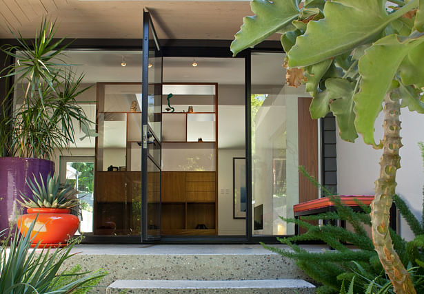 View from the entry stairs. The front entry was designed as a steel/glass wall so the garden and house flow together. A new polished seeded concrete deck and steps supports the mid-century origins of the house.