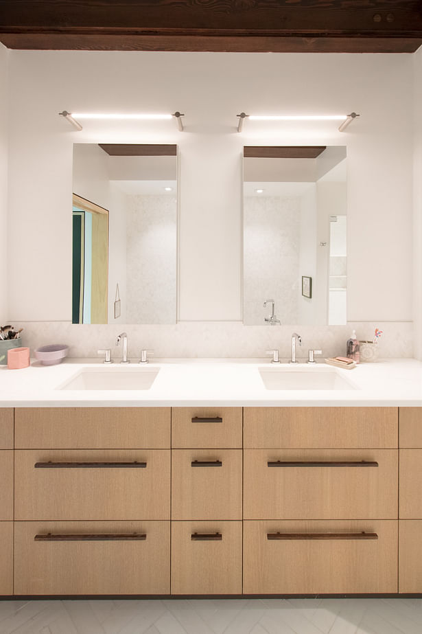 A new custom built-in vanity includes pulls from the original cabinet, which were incorporated throughout as a nod to the original design.