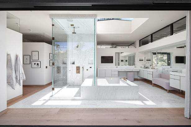 Photography by Taiyo Watanabe. The home’s expansive master bathroom features His and Hers commodes, Calcutta marble heated floors, central steam shower, spa tub, countertops and splash, wall-to-wall mirrors, and pocketing sliding doors to the deck.