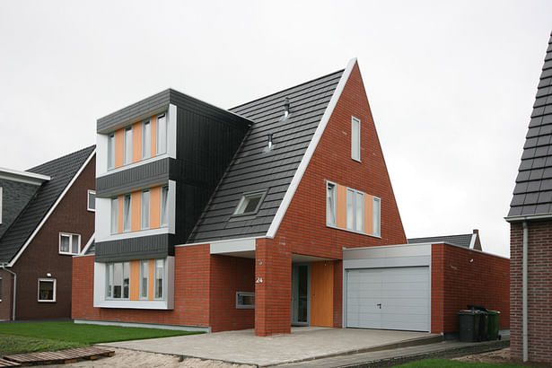 The light gray PVC window frames in the side facades are placed in the plane of the brick facade to strengthen the abstract image.