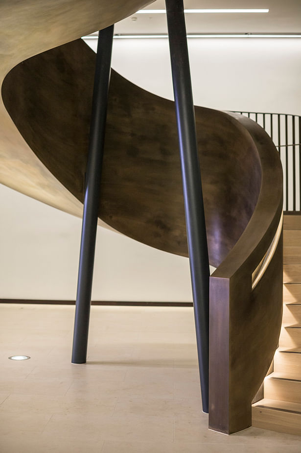 Two steel columns pierce the centre of the staircase