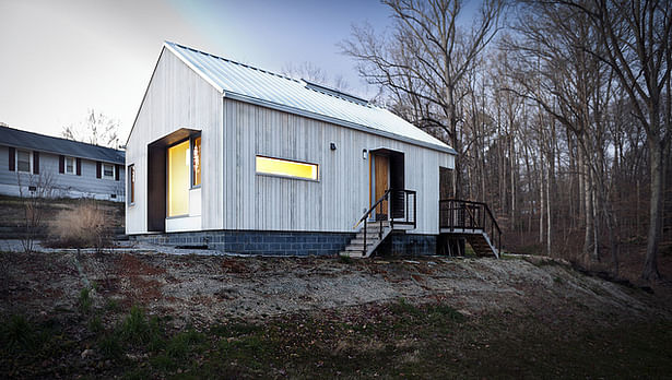 house exterior - the house adopts the basic form of the original 1930's 'norris cottage,' reintroducing a natural material palette (photo credit ken mccown)