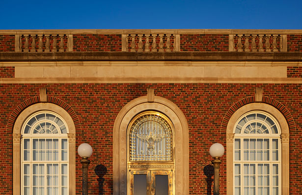 The main entrance with the bronze doors, eagle and the adjacent arched windows are shaded from the inside to create a hint of the new contents.