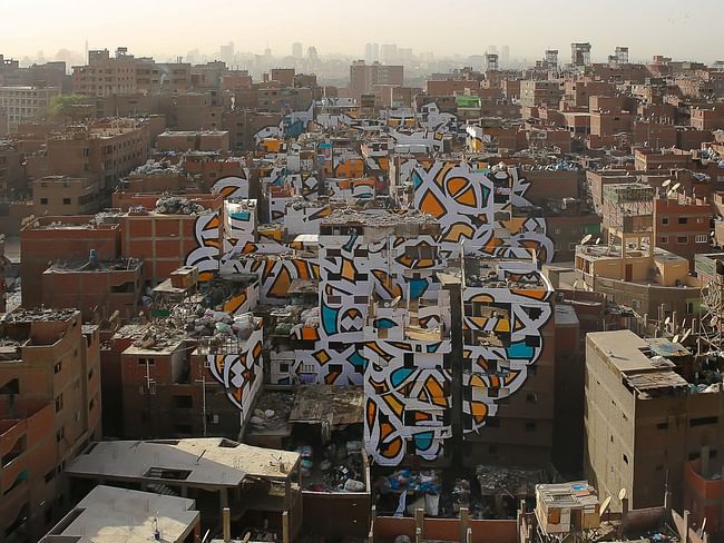 The piece 'Perception' by Tunisian-French artist eL Seed spans over numerous brick buildings in Cairo's neglected Manshiyat Naser neighborhood. (Photo: eL Seed; Image via techinsider.io)