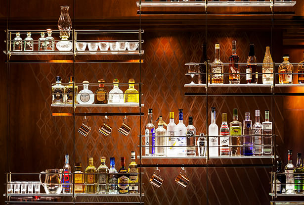 Detail: Floor-to-ceiling structurally tensioned bronzed stainless steel cable, electrified bottle shelving.