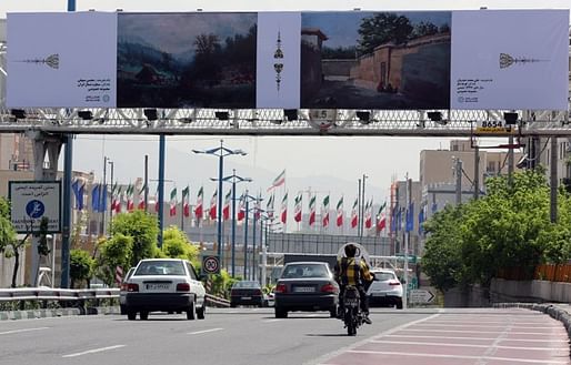 Cars drive past billboards in the Iranian capital of Tehran displaying art pieces from local and foreign artists. (Atta Kenare/AFP/Getty Images)