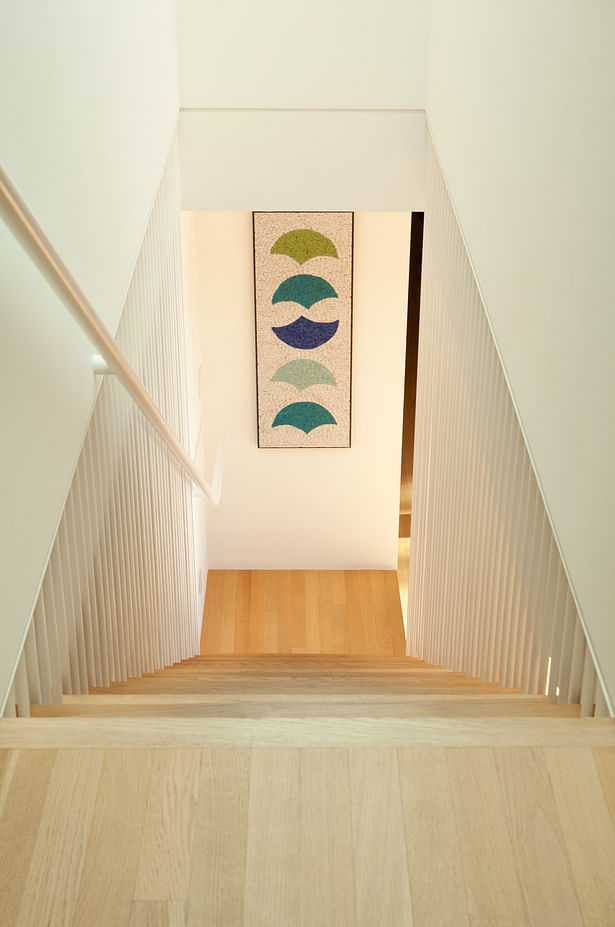A new staircase connects the upstairs to what was formerly more of a recreational basement/ lower floor. The stair is positioned to best allow our clients to walk from the kitchen/dining area downstairs, where new sliding glass doors lead to the pool area.